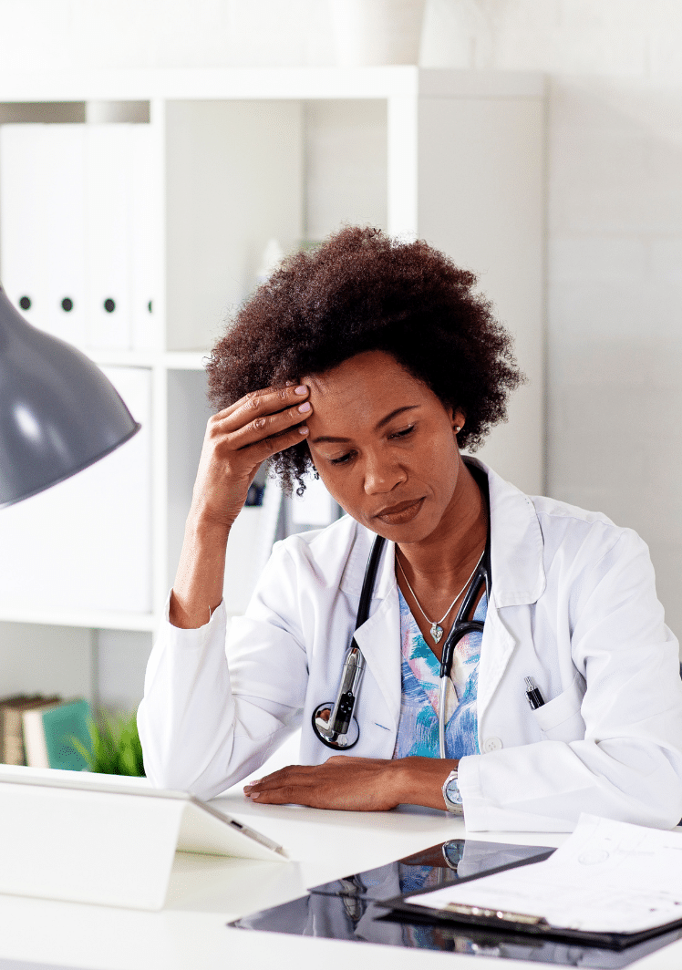 female doctor at a desk stressed about marketing